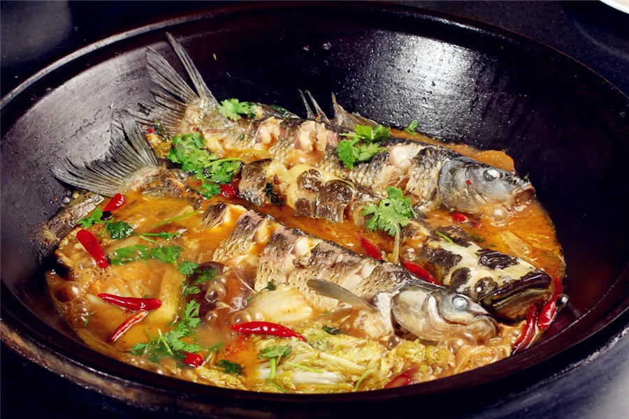 Harbin Cuisine - Stewing fish in a big iron pan on firewood 